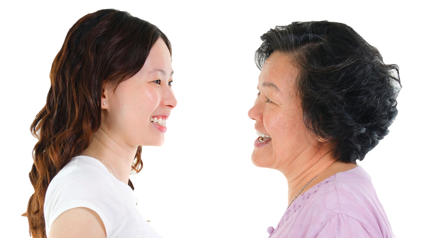 Senior Asian mother and her adult daughter facing each other in profile and smiling warmly